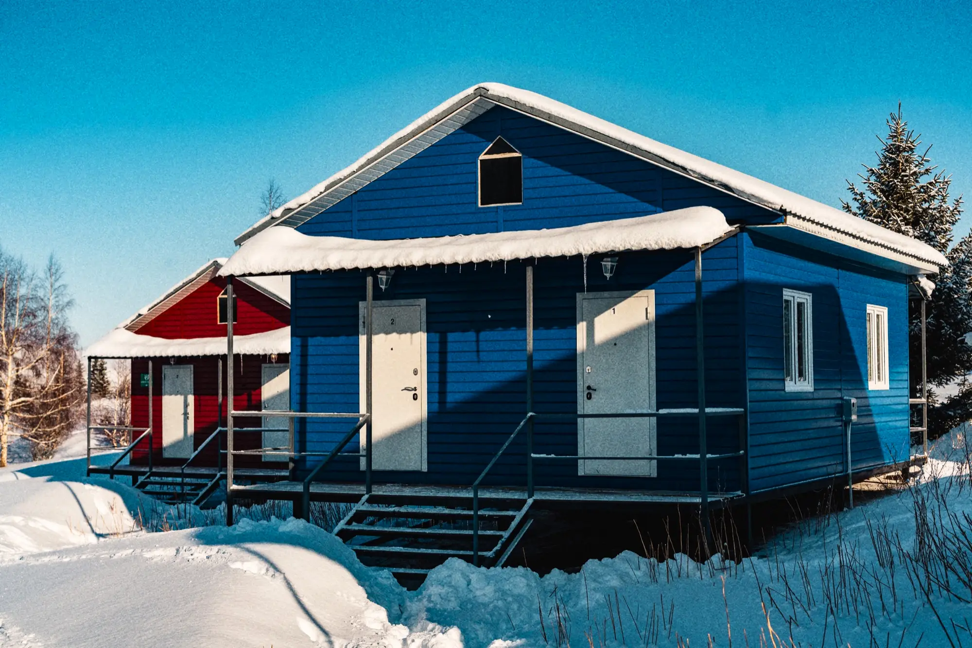 Blauwe houten hut van het base camp in de sneeuw