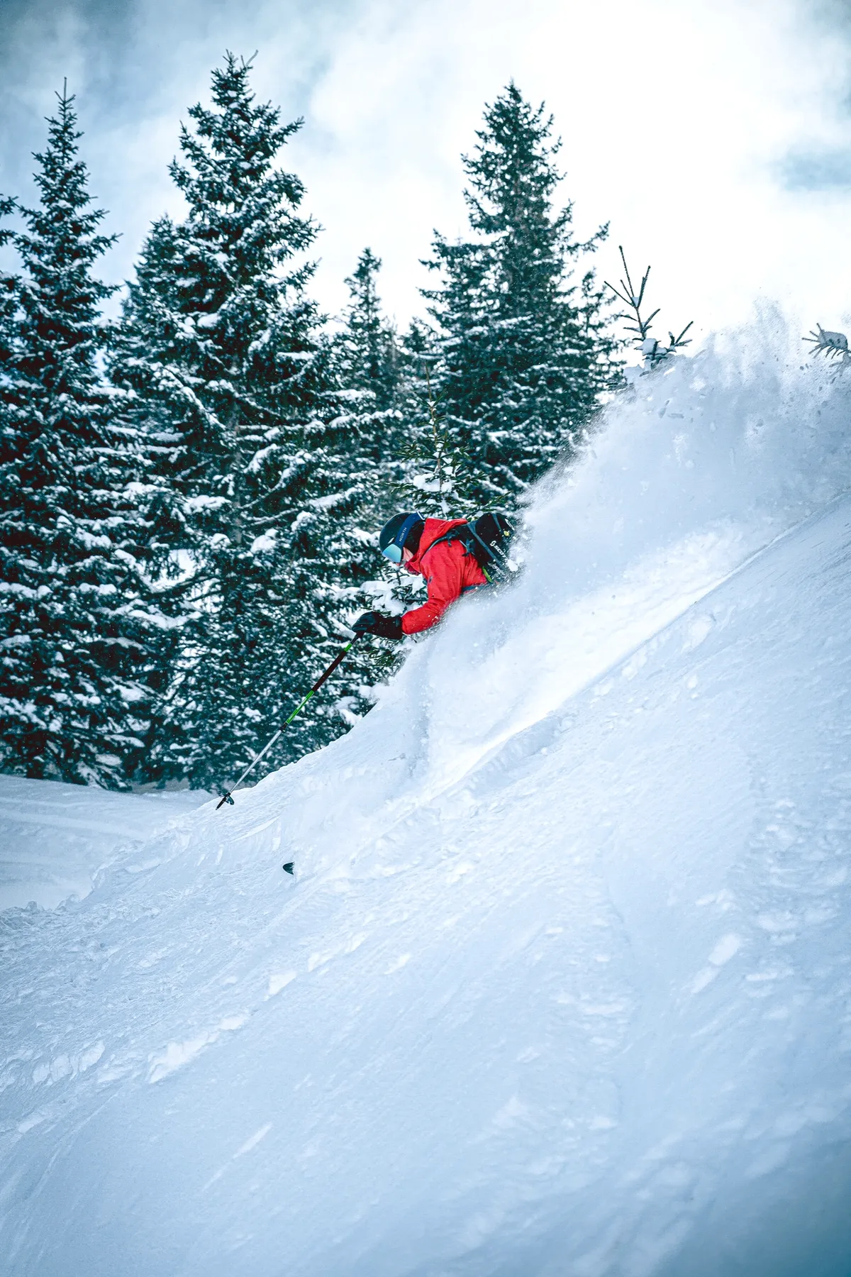 Skiër die steil door het bos rijdt