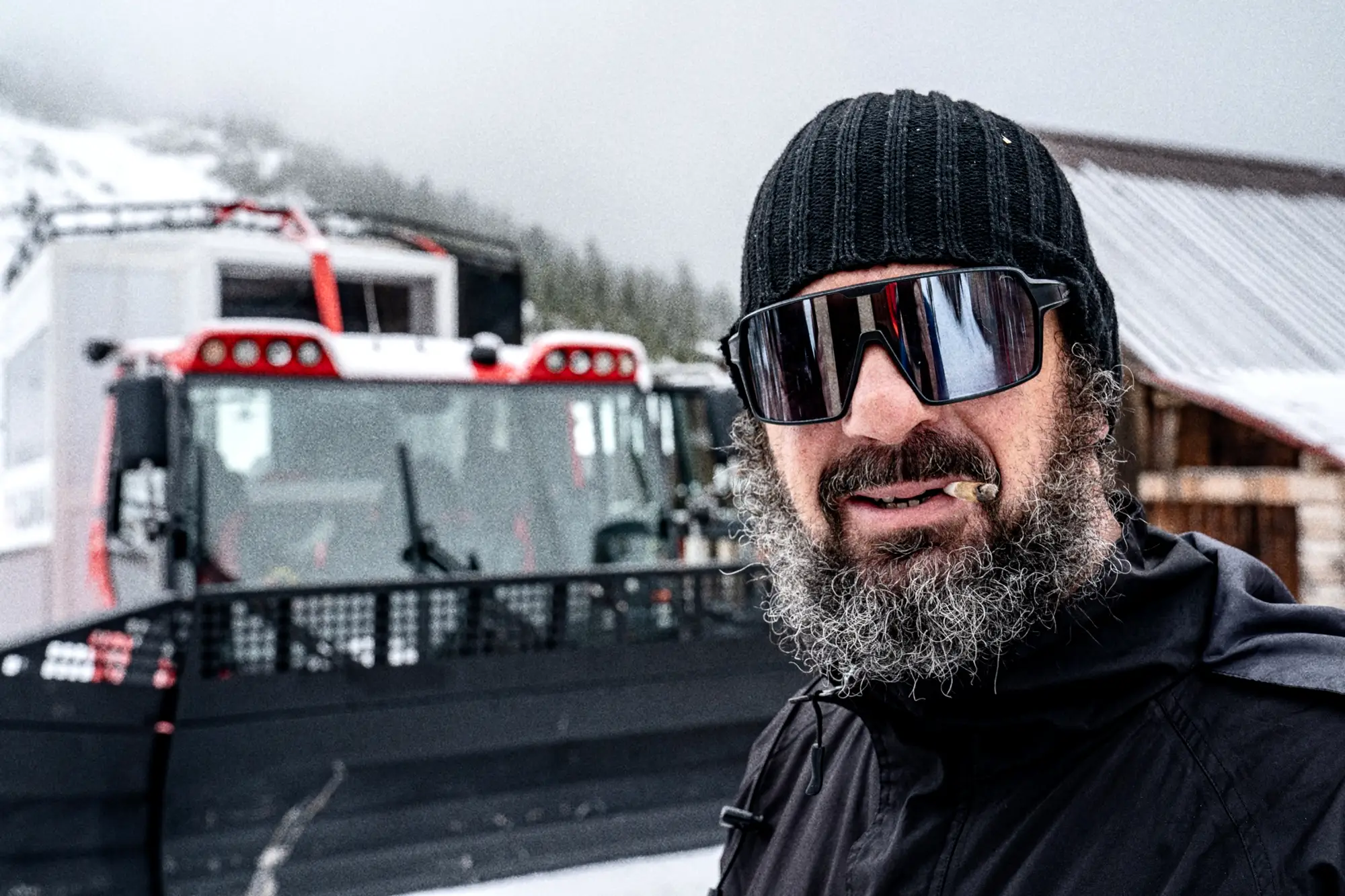Lokale snowcat-operator voor zijn machine, in de sneeuw