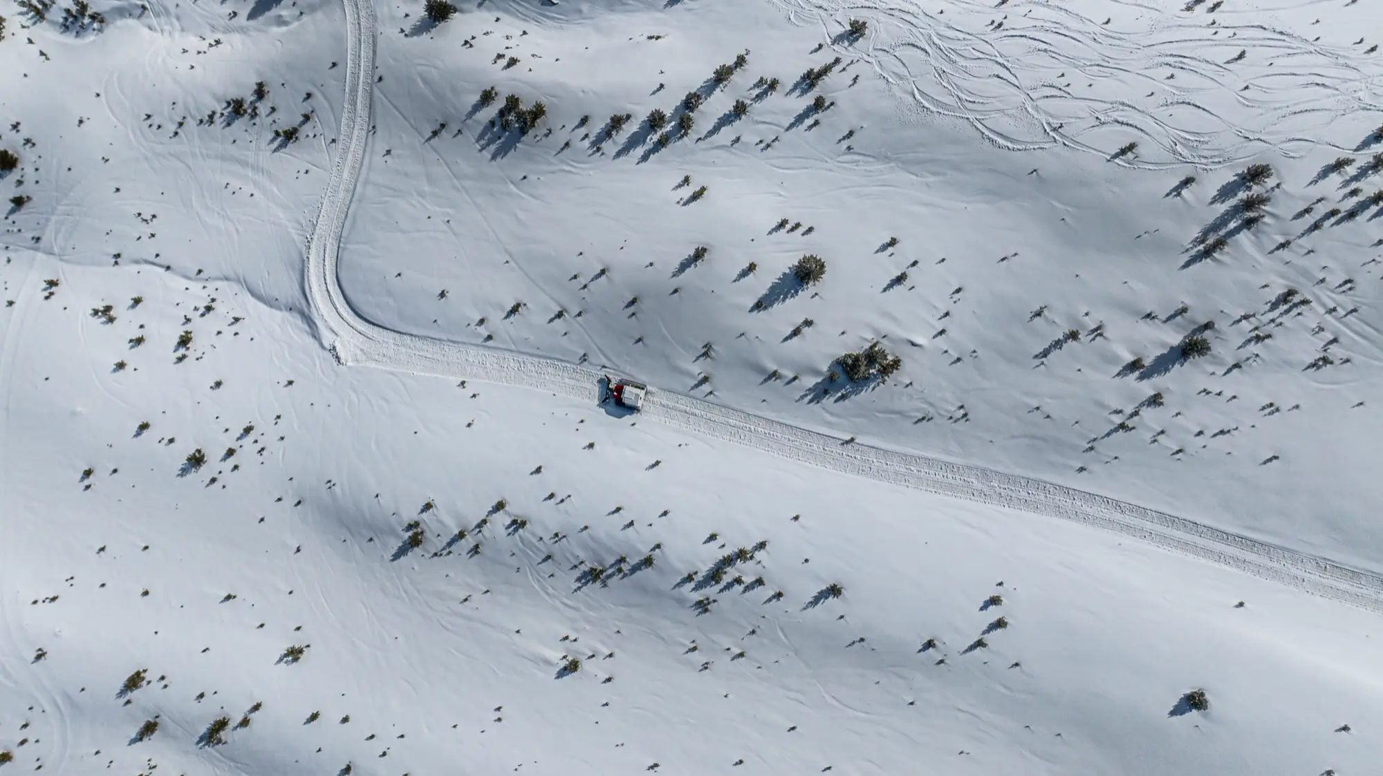 Luchtfoto van een catspoor door een besneeuwde helling